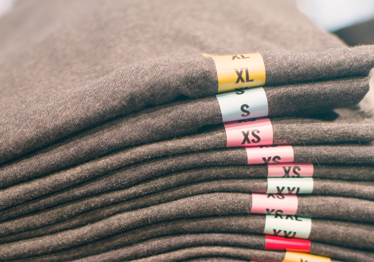 clothing size stickers on folded shirts